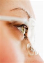 Studio close-up of woman wearing eyeglasses.