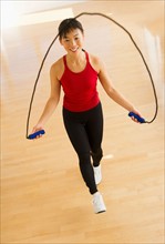 Mid adult woman training with skipping rope.