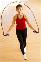 Mid adult woman training with skipping rope.
