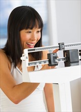 Smiling woman checking her weight.
