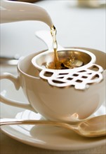 Close-up of water falling into tea cup.