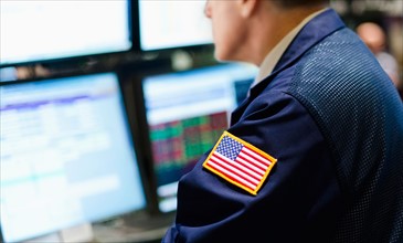 Stock trader with american flag on sleeve.
