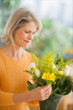 Portrait of senior woman arranging bouquet in Mother's Day.