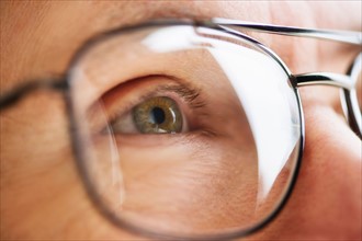 Close up of men's eye looking through glasses.