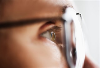 Close up of men's eye looking through glasses.