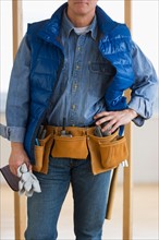 Construction worker wearing tool belt.