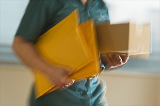 Deliver man carrying boxes and envelopes.