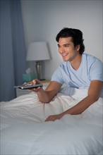 Man watching tv in bed.
