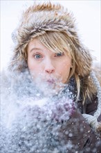 Woman blowing snow.