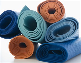 Stack of exercise mats on white background. Photo : Jamie Grill