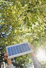Hand holding solar panel in park. Photo : Jamie Grill