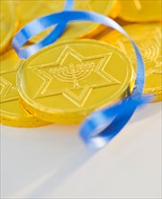 Studio Shot of chocolate coin and blue ribbon. Photo : Daniel Grill