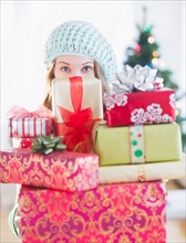 Young woman with stack of colorful Christmas gifts. Photo : Daniel Grill