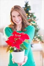 Young woman with red poinsettia. Photo : Daniel Grill