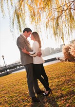 USA, New York, Long Island City, Young couple embracing in park. Photo : Daniel Grill