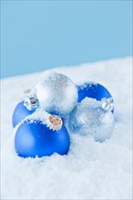 Studio shot of blue and silver christmas ornament on snow. Photo : Daniel Grill