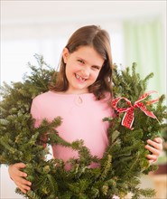 Portrait of girl (8-9) with christmas wreath. Photo : Daniel Grill