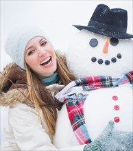 Portrait of young woman with snowman. Photo : Daniel Grill