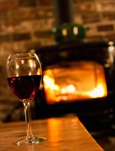 Wine glass with fireplace in background. Photo : Daniel Grill