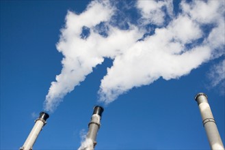 Low angle view of factory chimneys. Photo : fotog