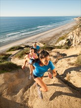 USA, California, San Diego, Three people jogging along sea coast.