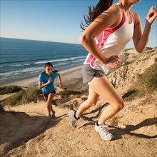 USA, California, San Diego, Two women jogging along sea coast.