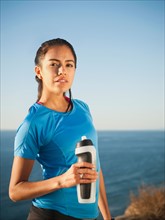 USA, California, San Diego, Portrait of female jogger holding water bottle.
