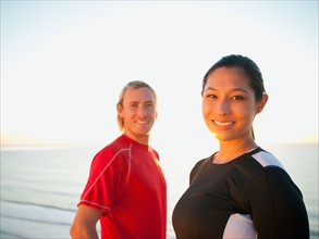 Portrait of male and female joggers at sea.