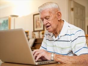 Senior man using laptop.
