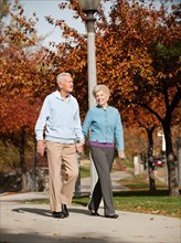 Senior couple strolling in park.