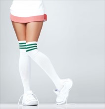 Low section of woman wearing sneakers and knee-high socks. Photo : Yuri Arcurs