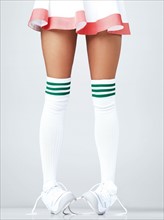 Low section of woman wearing sneakers and knee-high socks. Photo : Yuri Arcurs