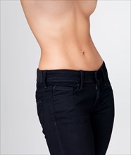 Midsection of slim young woman with flat belly. Photo : Yuri Arcurs