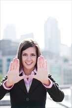 USA, Seattle, Smiling businesswoman making frame with hands. Photo : Take A Pix Media