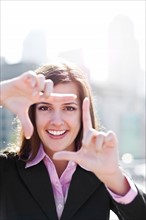 USA, Seattle, Smiling businesswoman making frame with hands. Photo : Take A Pix Media