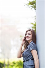 Young elegant woman standing and talking via phone. Photo : Take A Pix Media