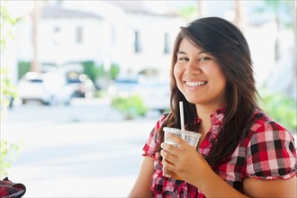 USA, California, La Quinta, Portrait of young woman drinking tea in outdoor cafe. Photo : Sarah M.