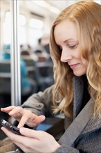 Woman sending text messages in subway train. Photo : Sarah M. Golonka