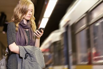 USA, California, Los Angeles, Woman sending text messages on subway station. Photo : Sarah M.