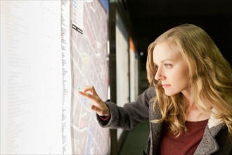 USA, California, Los Angeles, Woman at subway station checking map. Photo : Sarah M. Golonka