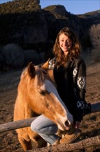 Portrait of young smiling woman with horse. Photo : John Kelly