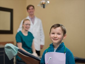 Portrait of patient, dentists in background. Photo : Dan Bannister