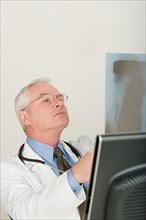 Doctor looking at x-ray image. Photo : Rob Lewine