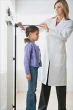 Doctor measuring girl (10-11). Photo : Rob Lewine