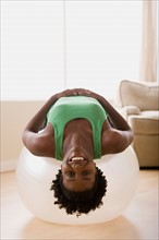 Woman lying down on fitness ball. Photo : Rob Lewine