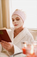 Woman with facial mask reading book. Photo : Rob Lewine