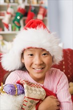 Portrait of teenage Girl (10-11) wearing santa hat. Photo : Rob Lewine
