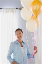 Portrait of mature woman with balloons. Photo : Rob Lewine