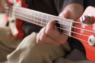 Man playing bass guitar. Photo : Rob Lewine