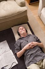 Portrait of man lying on floor with headphones. Photo : Rob Lewine